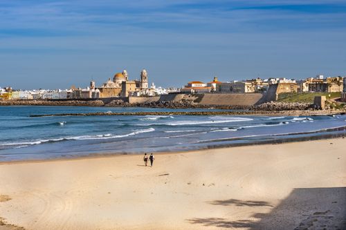 Free Captivating view of Cádiz Cathedral with a sandy beach foreground, perfect for travel themes. Stock Photo