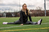 在纽约州牡蛎湾，一名女子穿着运动服在草地上劈叉