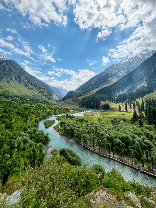 Free Breathtaking view of lush valleys and river in Kashmir under a vibrant blue sky. Stock Photo