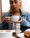 Woman in Blue Denim Jacket Holding White Ceramic Mug