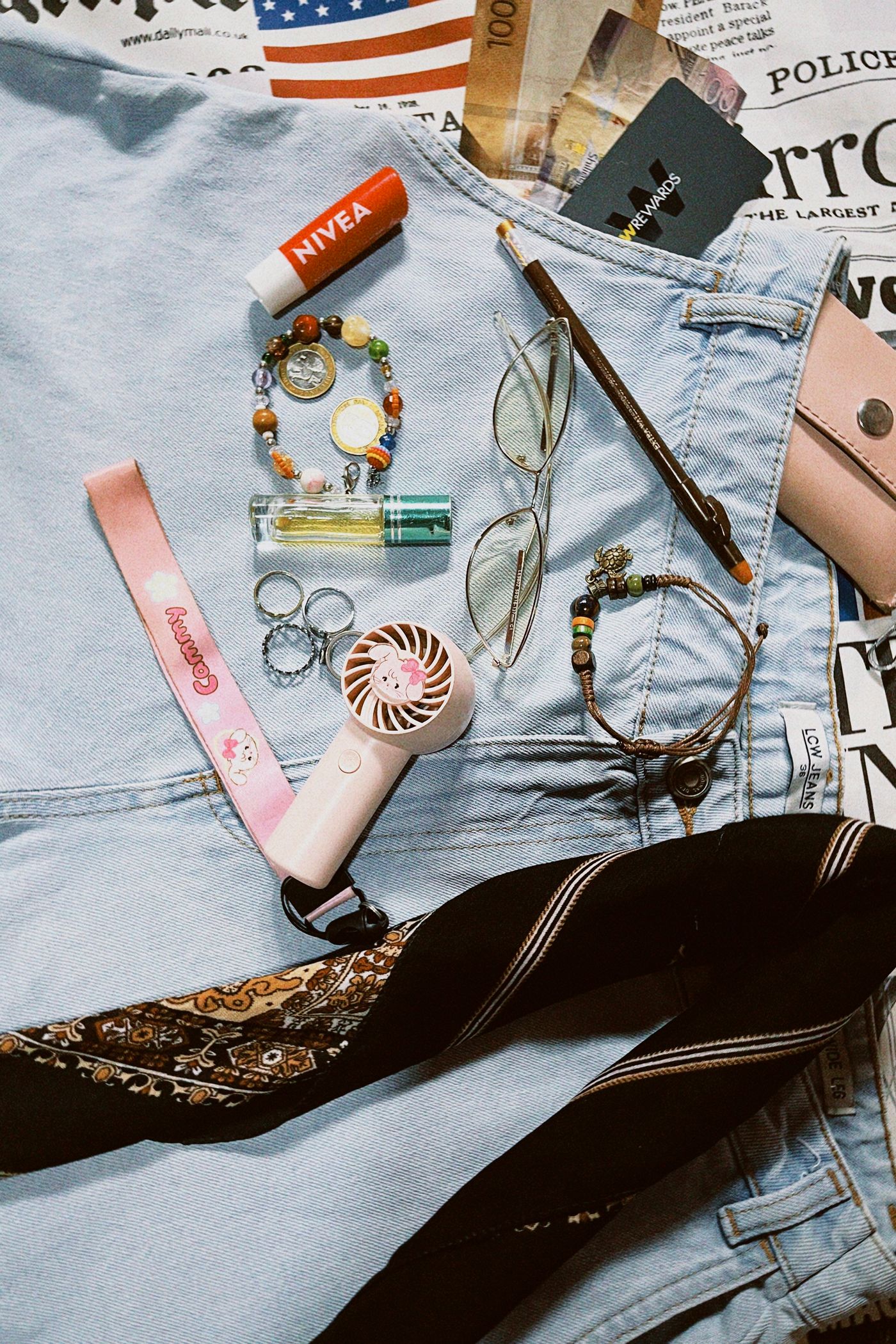 Fashion accessories arranged over denim in a clean flat lay without people