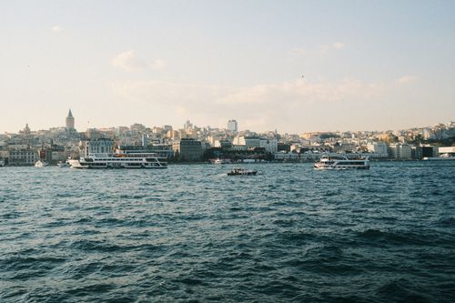 Free View of Istanbul skyline from the Bosphorus Strait, showcasing ferries and the Galata Tower. Stock Photo