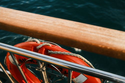 Free Close-up of a lifebuoy on a boat railing overlooking the sea, symbolizing safety. Stock Photo