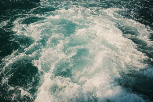 Free Aerial view of turbulent ocean waves with frothy white crests and deep blue water. Stock Photo