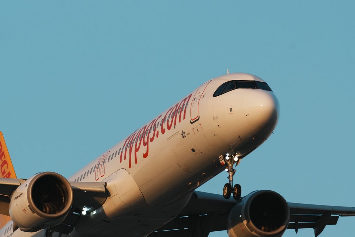 Passenger aircraft approaching for landing over clear blue sky at Istanbul airport. Illustrative editorial photograph.