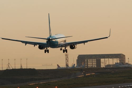 Free A jet plane makes a smooth landing at Istanbul Airport during sunset, showcasing aviation precision. Stock Photo