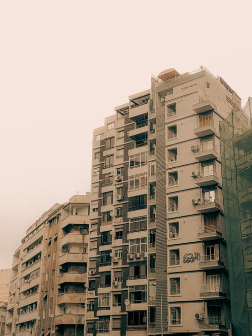 Free High-rise apartment building with air conditioners and Arabic graffiti in urban setting. Stock Photo