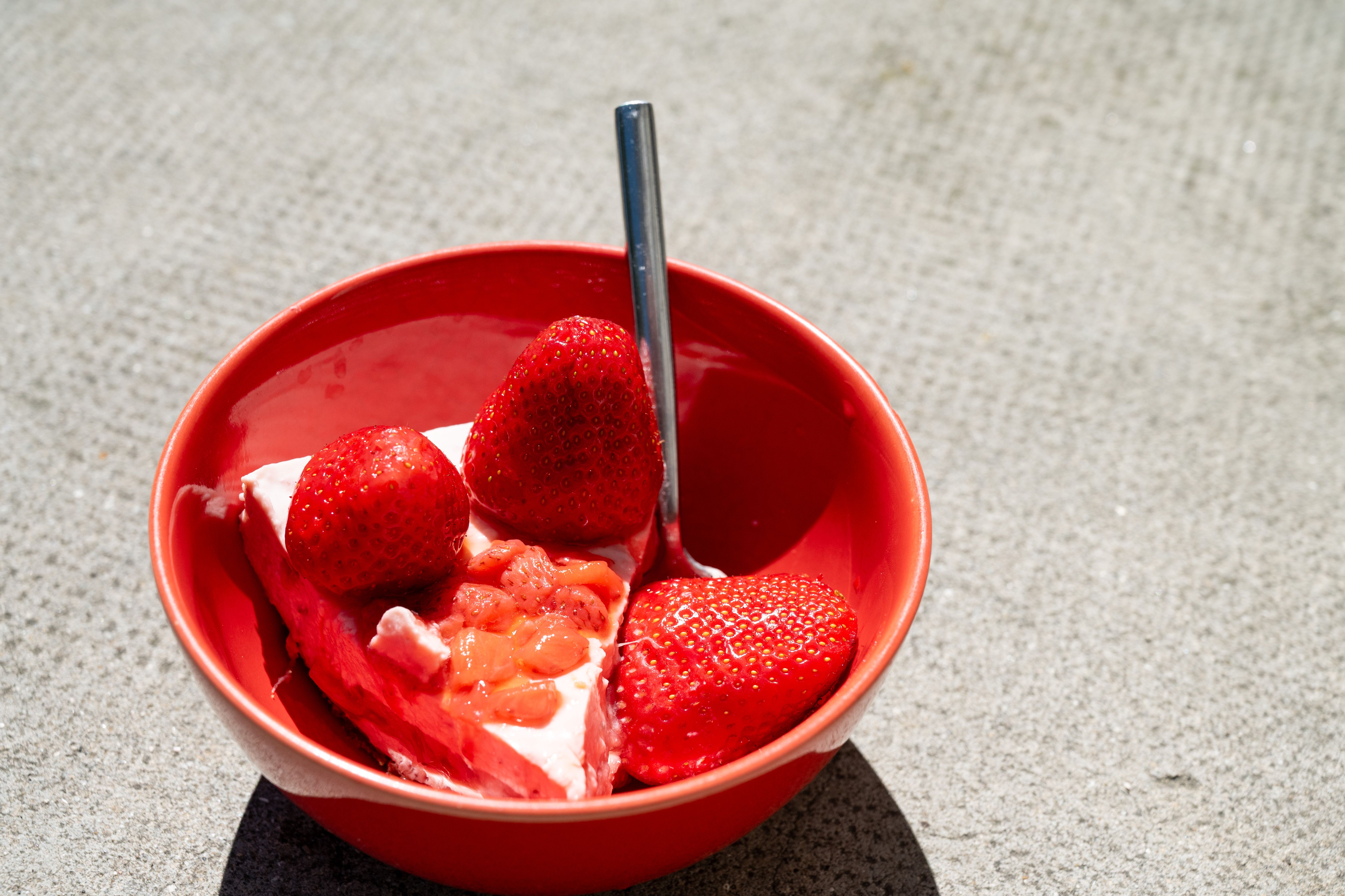 Close-up of creamy no-bake strawberry cheesecake topping with fresh strawberry slices