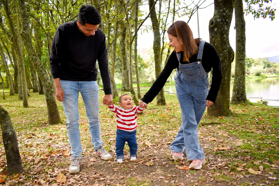 Una familia feliz disfruta de un paseo bajo la exuberante vegetación del parque.