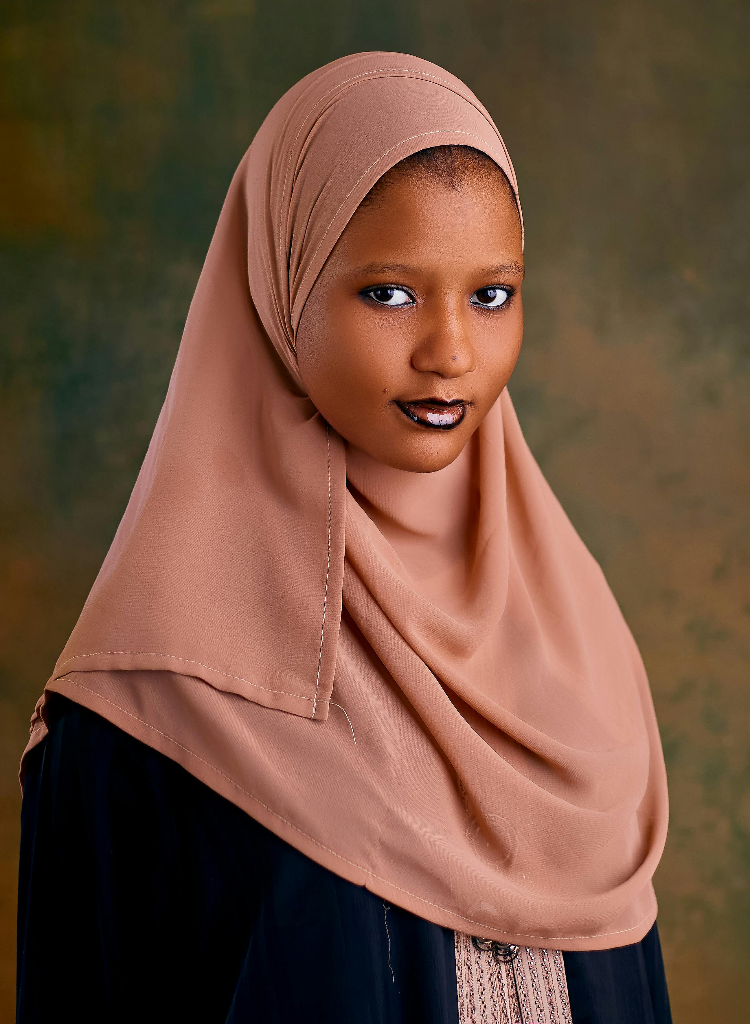 Sophisticated portrait of a woman wearing a hijab with a neutral background.