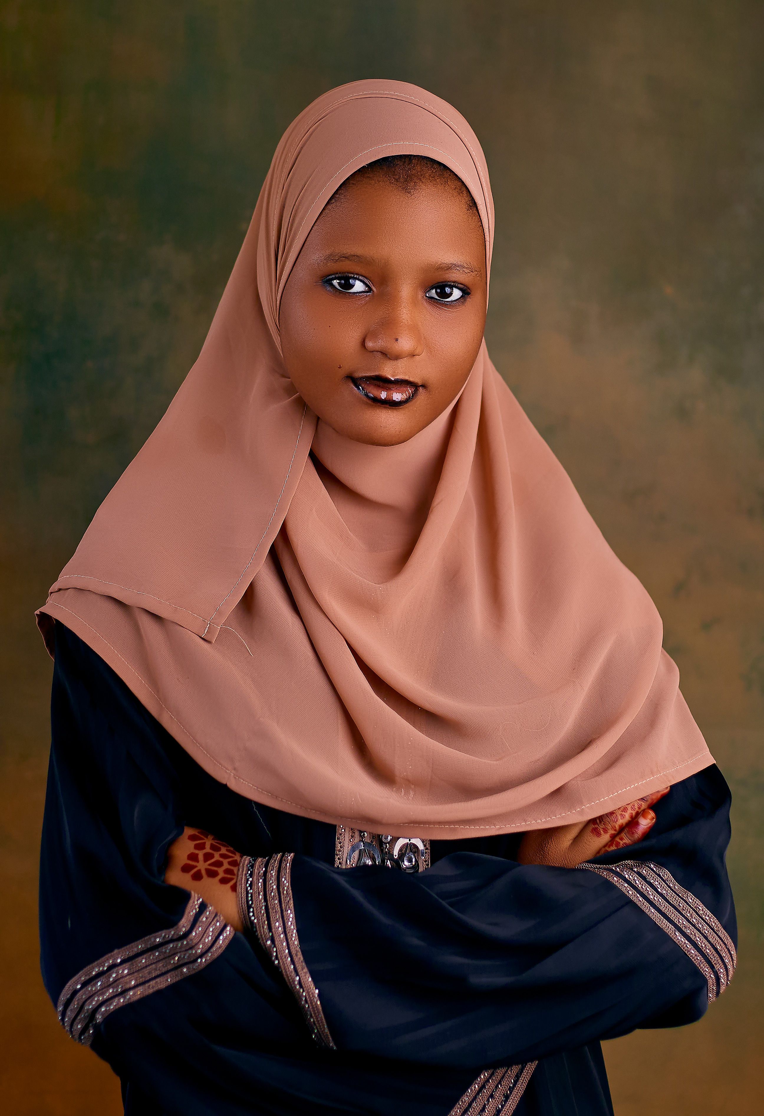 Portrait of a woman in traditional attire with a confident pose and henna.