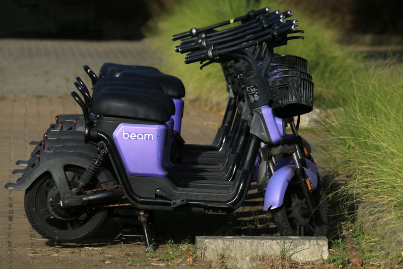 Purple Beam e-scooters parked in a row on a sunny day, ideal for urban transport themes.