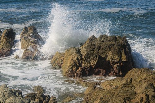 Free Waves crashing against rocks on the Mazatlán coastline, capturing the dynamic power of nature. Stock Photo