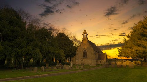 免费 棕色混凝土教堂日落时的照片 素材图片