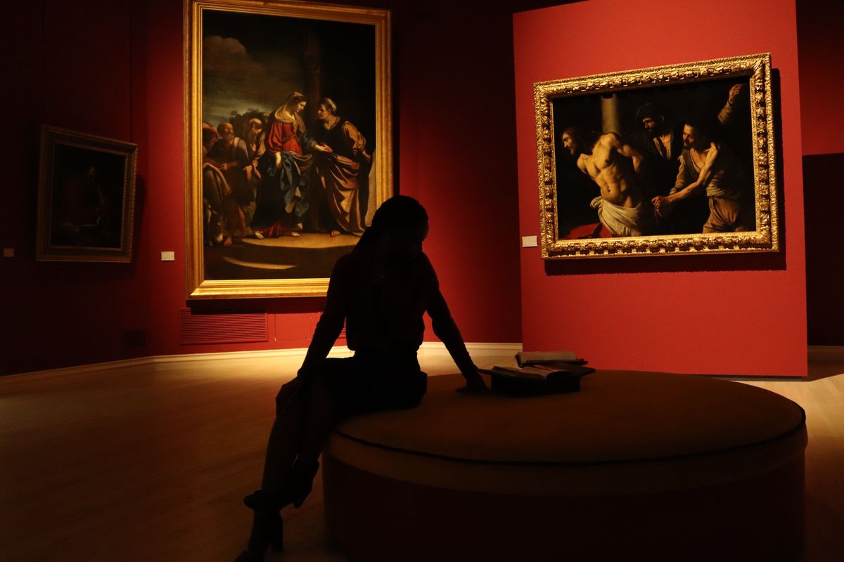 Silhouetted visitor in an art gallery with dramatic lighting
