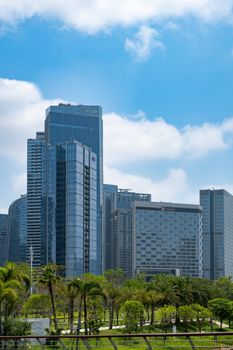 Tall glass skyscrapers in Shenzhen, China, under a bright blue sky.