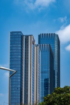 Tall glass skyscrapers under a clear blue sky in Shenzhen, China, showcasing modern architecture.