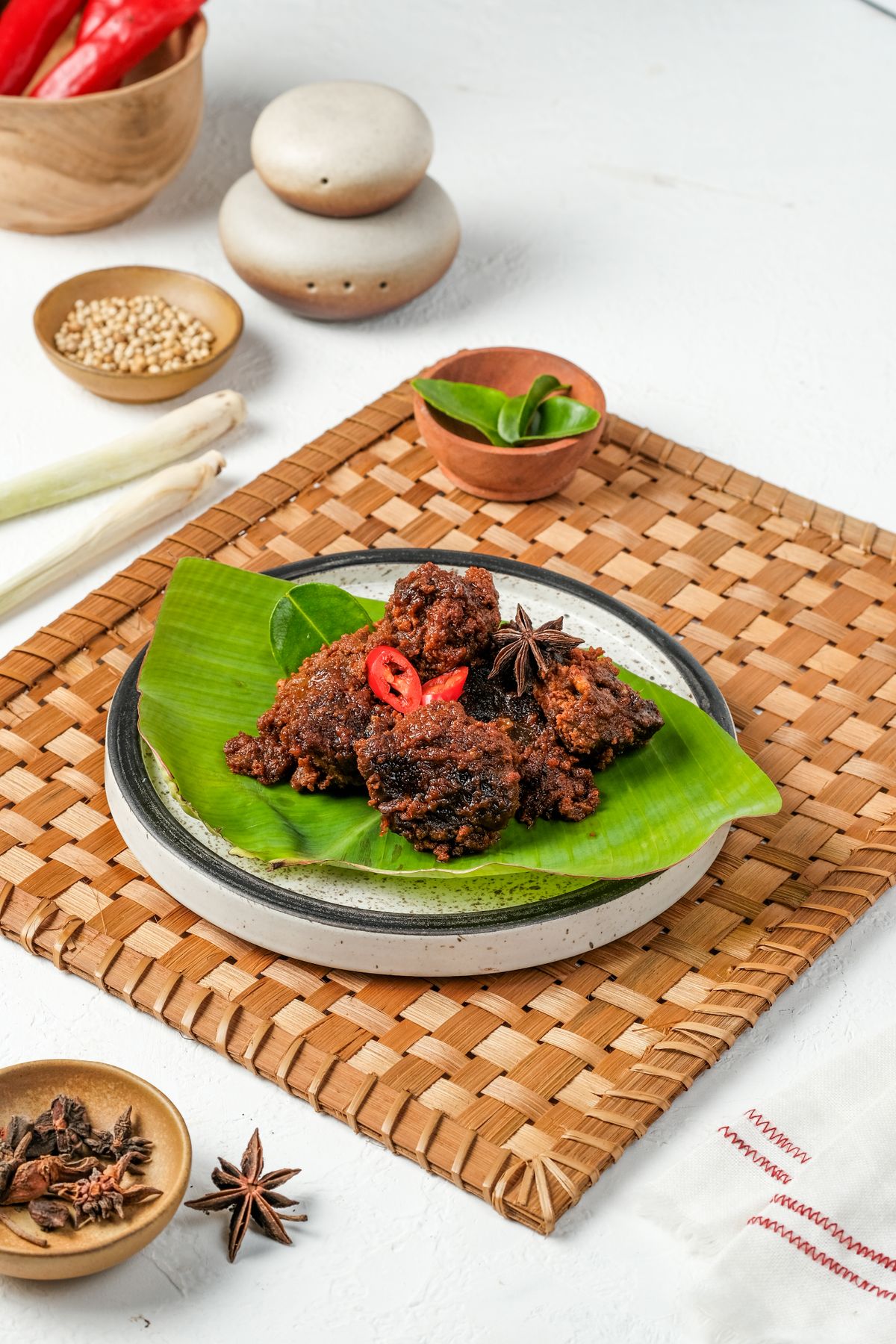 Authentic Indonesian beef rendang served on a banana leaf, garnished with red chili