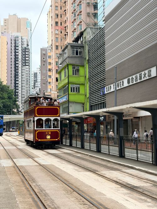 Free Iconic Hong Kong tram navigating between urban buildings during day. Stock Photo