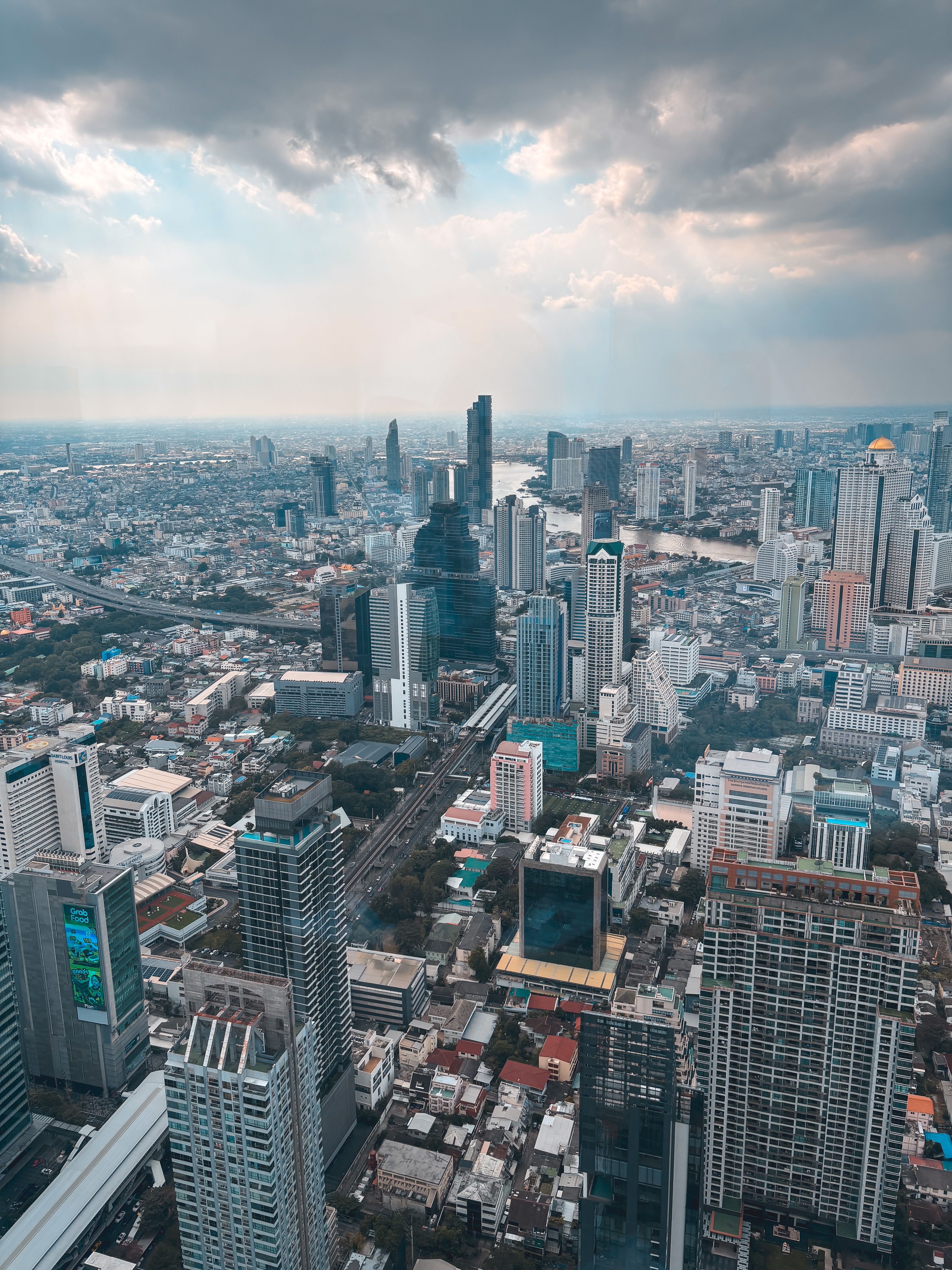 A breathtaking daytime view of the Bangkok city skyline featuring modern skyscrapers under dramatic clouds.