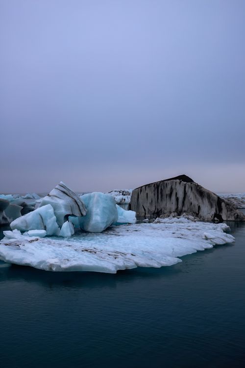 Free Captivating view of icebergs set against a tranquil dusk sky over calm waters. Stock Photo