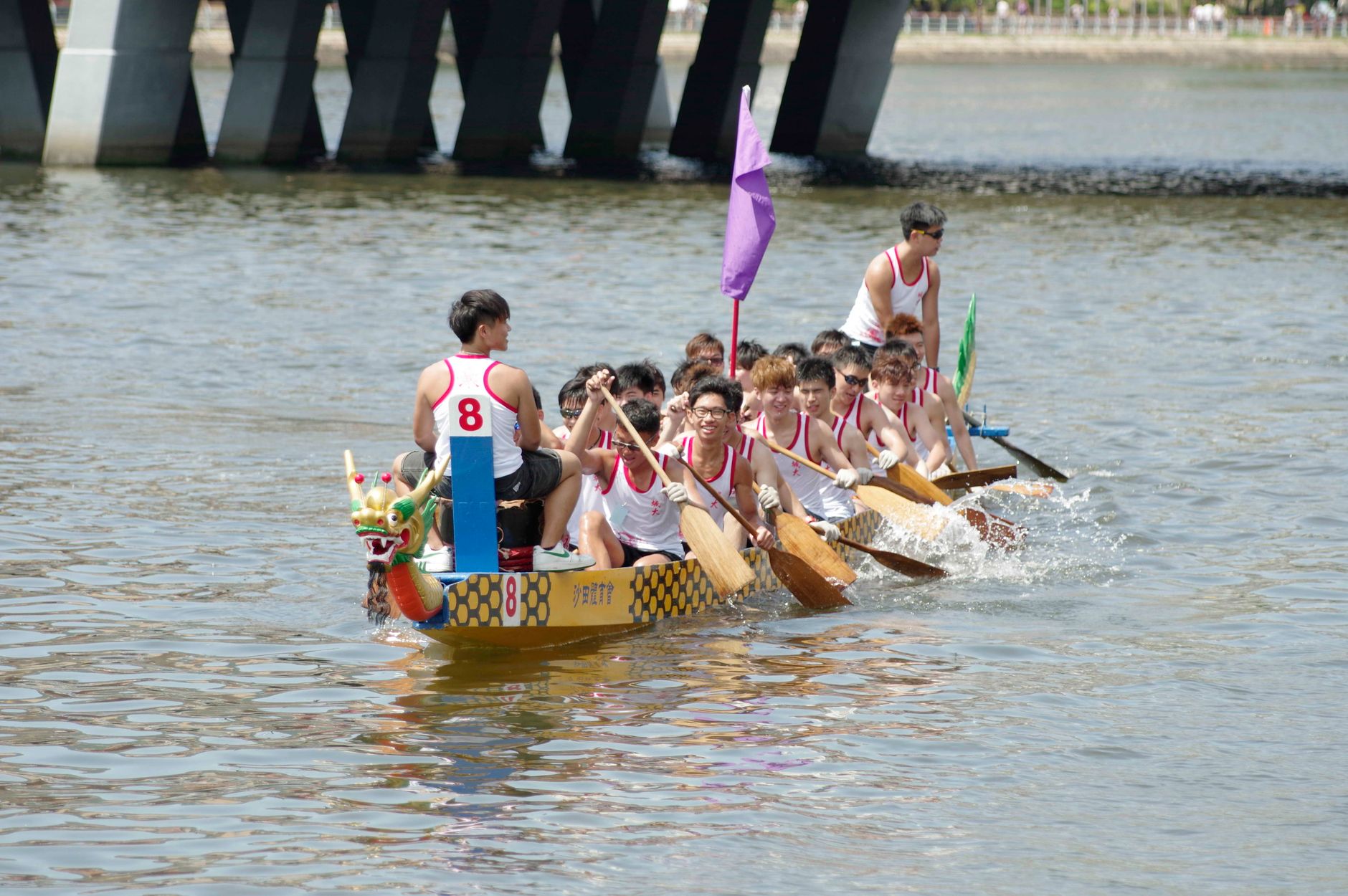 Competitors in a dragon boat race paddling vigorously on Shing Mun River, Hong Kong.