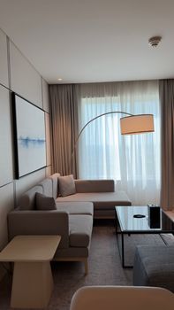 Bright modern living room with cozy couch, stylish lamp, and abstract art in a minimalist style.