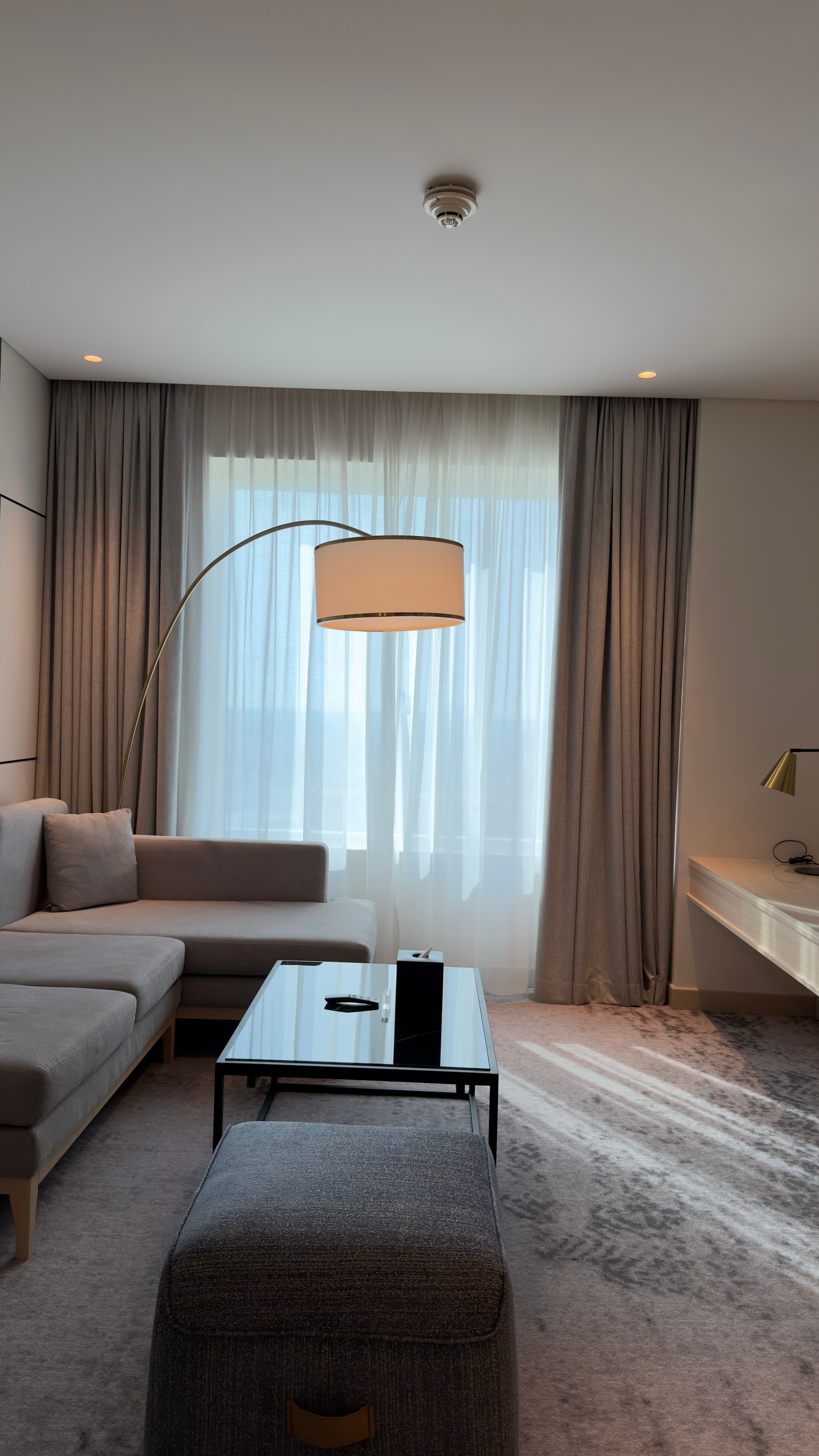 Modern extended-stay hotel suite interior with a sofa, lamp, and living area