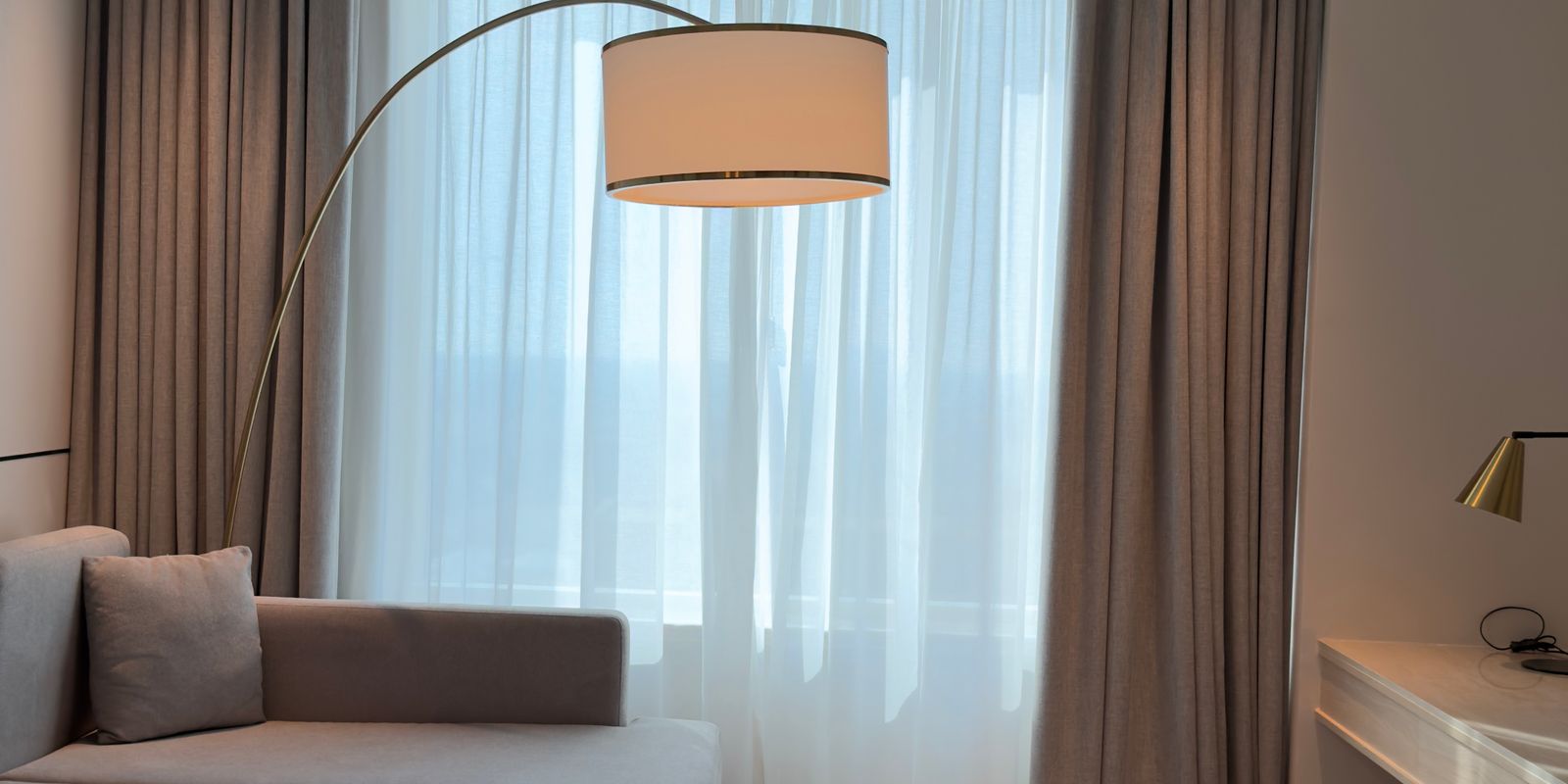 Modern extended-stay hotel suite interior with a sofa, lamp, and living area
