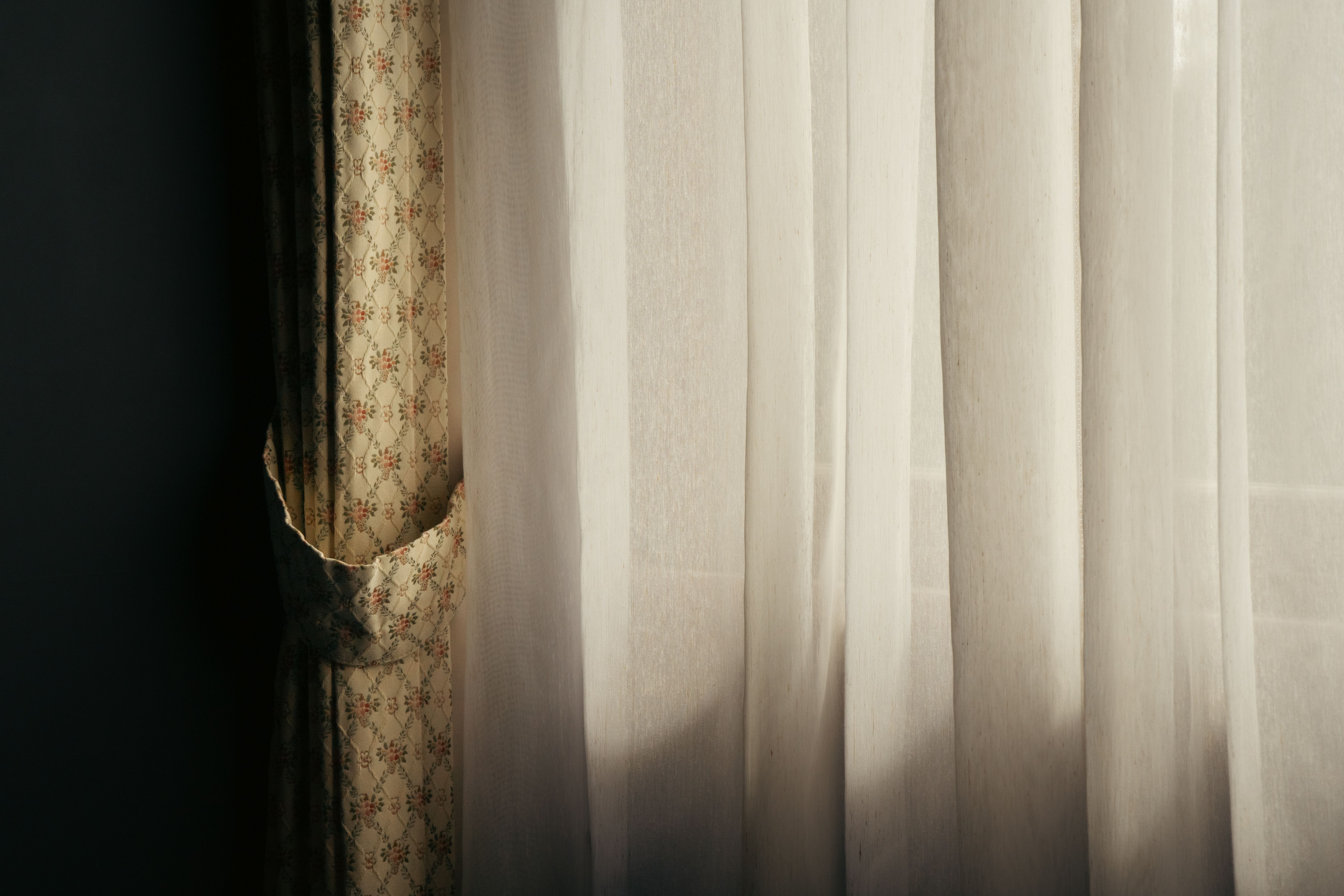 Kostenlos Warmes Sonnenlicht, das durch elegante Vorhänge in einem Zimmer in Tokio fällt, schafft eine ruhige Atmosphäre. Stock-Foto
