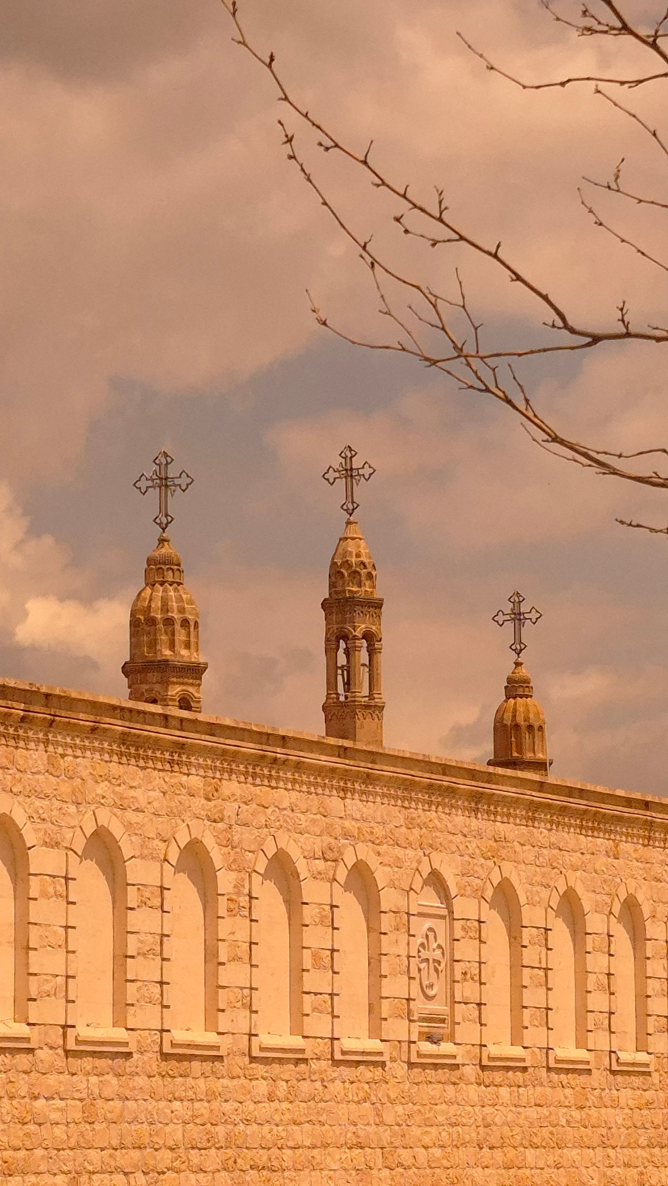 Historic stone church towers with crosses against a dramatic sky.