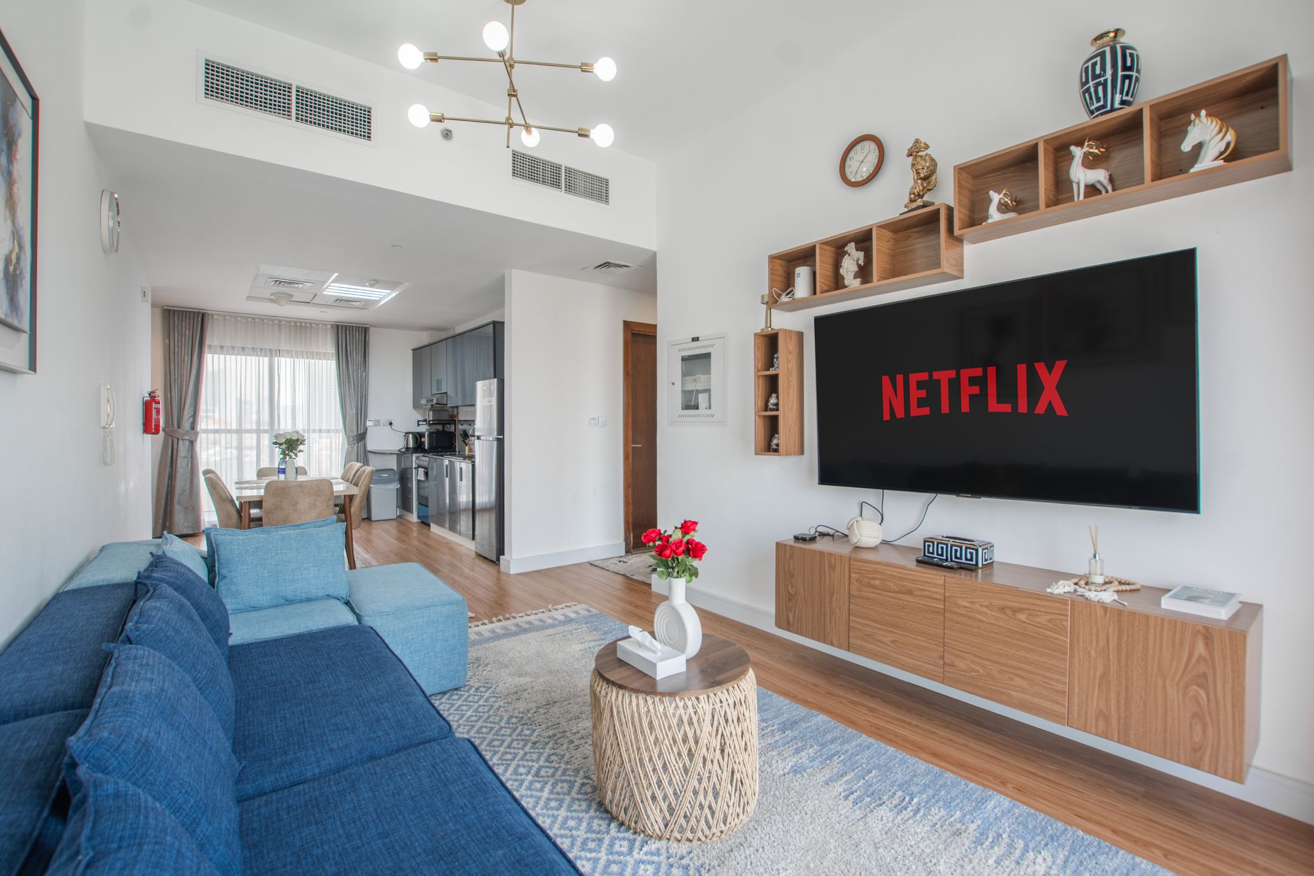 a premium living room television displaying JioHotstar cricket coverage beside a smartphone and remote control