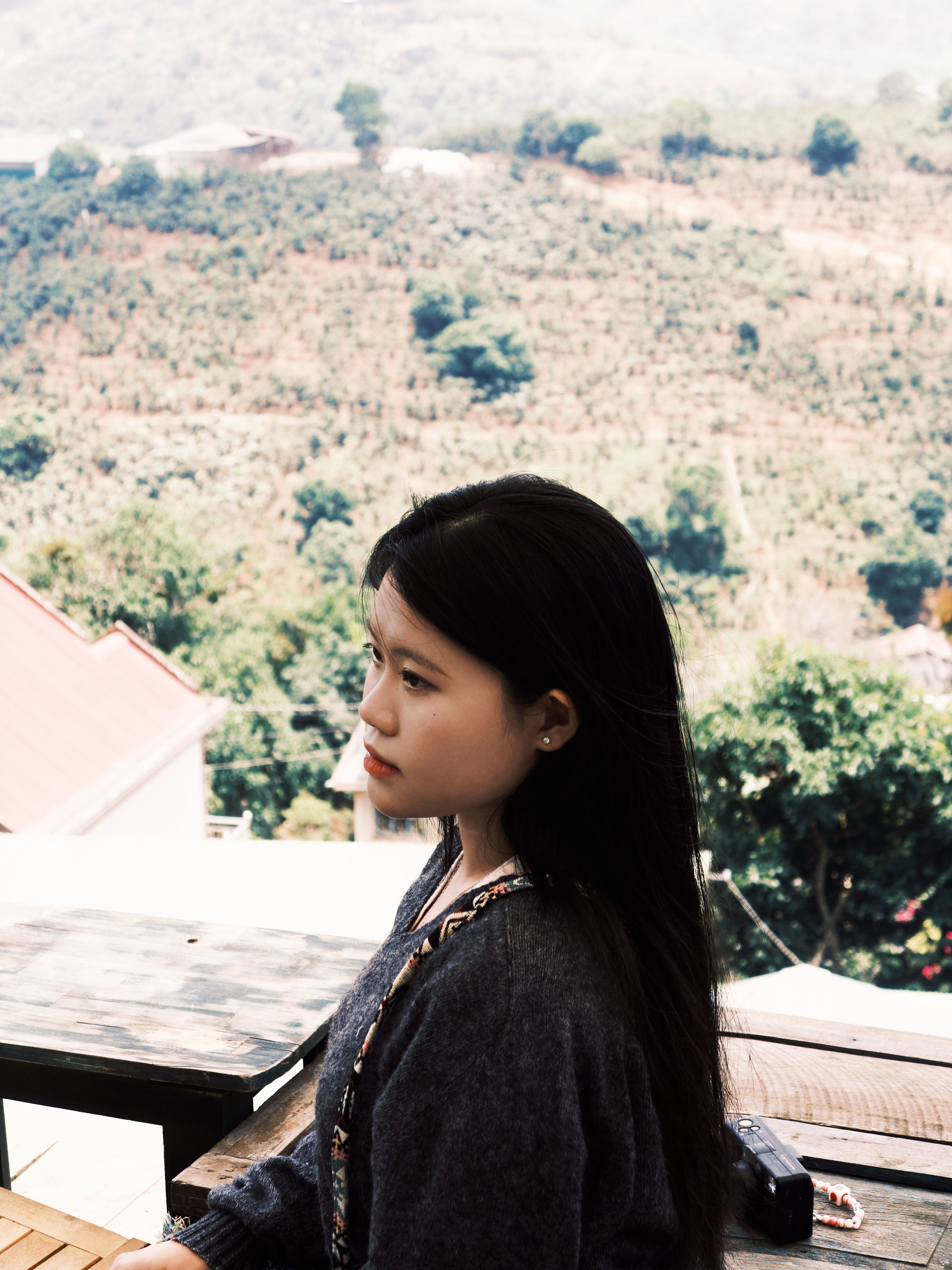 Young woman in profile with lush Xuân Trường landscape in the background, Đà Lạt, Vietnam.