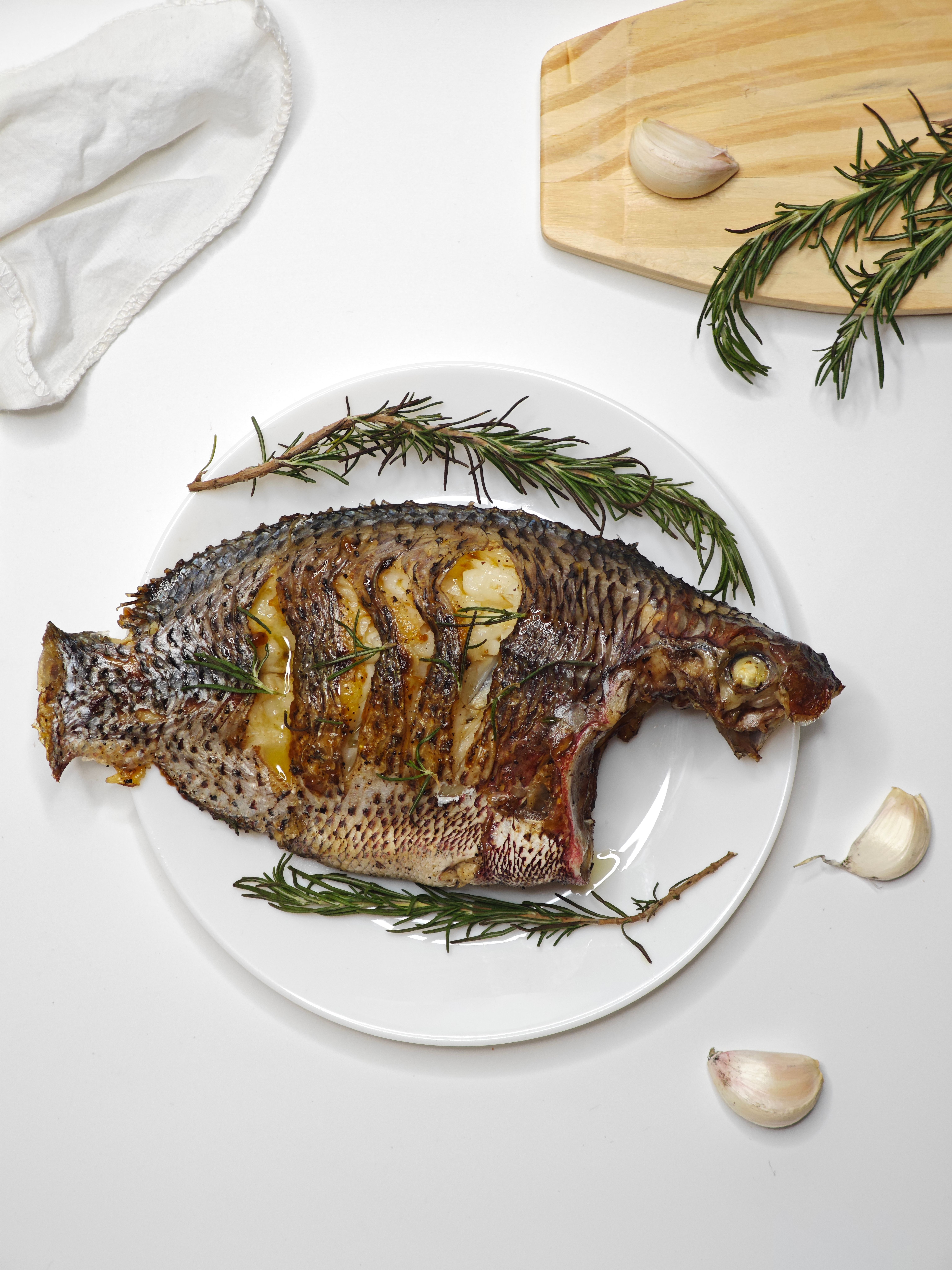 Deliciously grilled tilapia garnished with rosemary and garlic, perfect for a culinary feast.