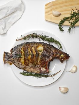 Deliciously grilled tilapia garnished with rosemary and garlic, perfect for a culinary feast.