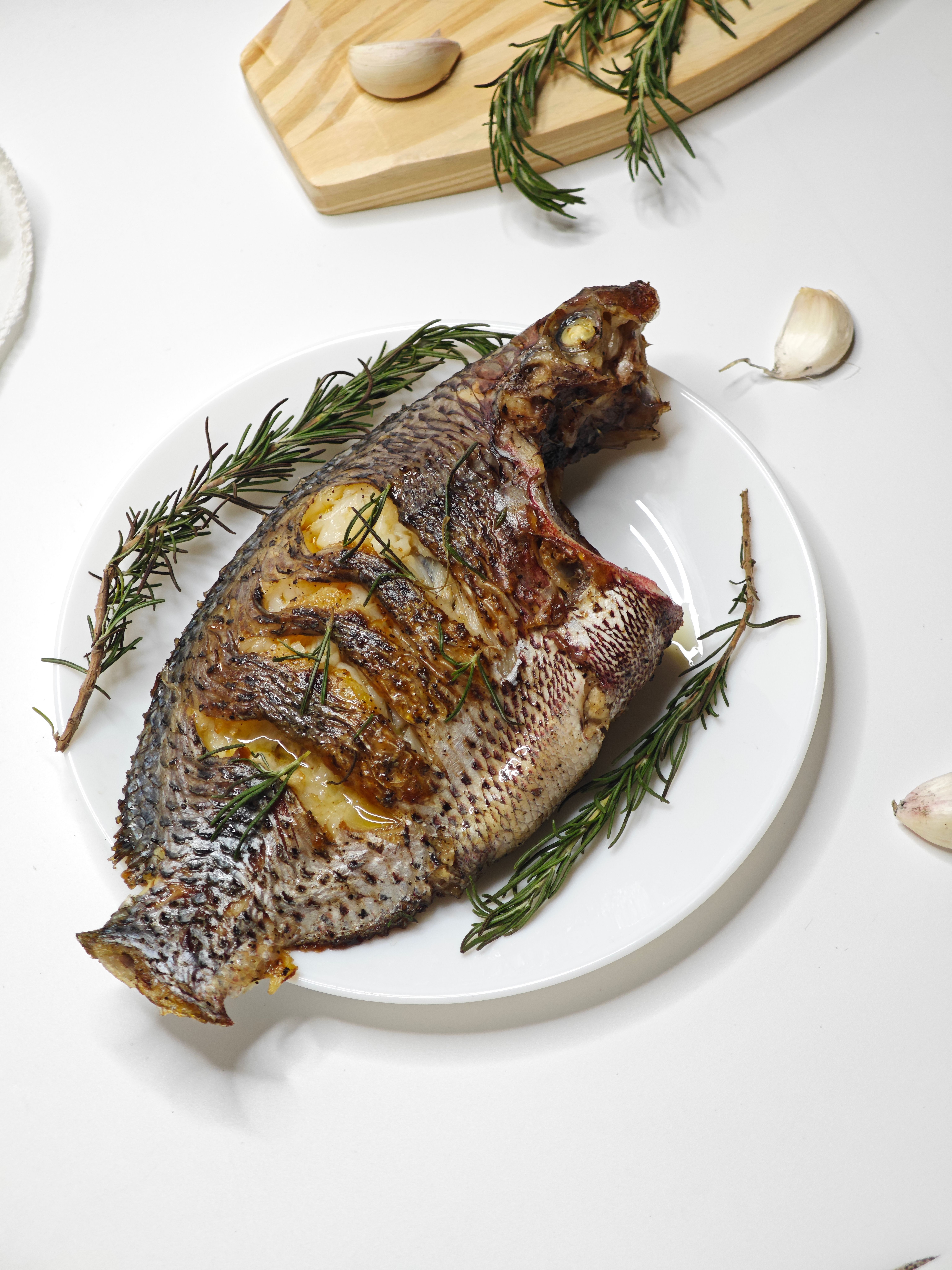 Grilled fish served with rosemary and garlic, perfect for gourmet meals.