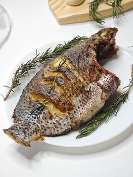 Deliciously grilled whole fish served with fresh rosemary, offering a gourmet dining experience.