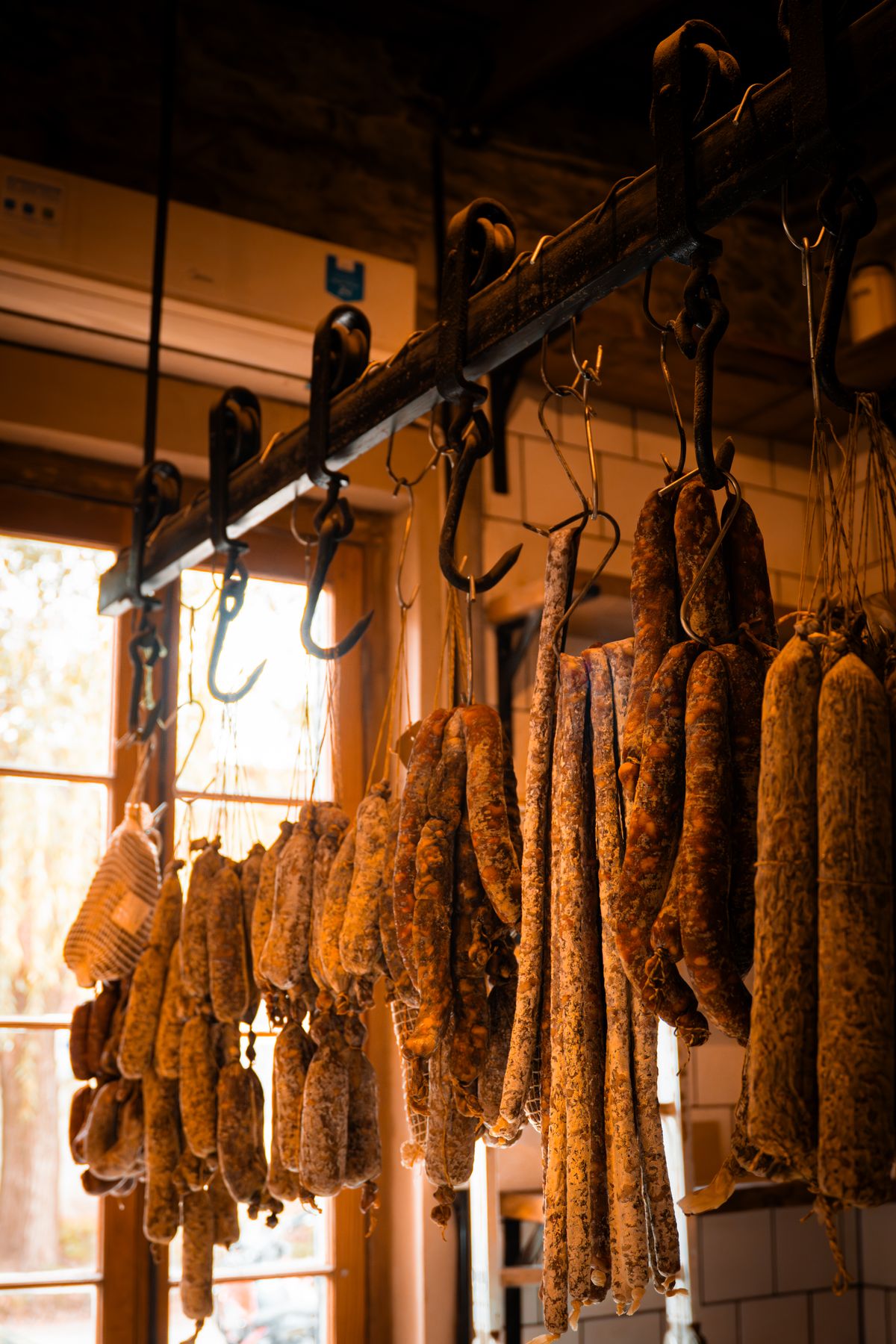 Cured saucisson hanging in a rustic Lyonnais charcuterie