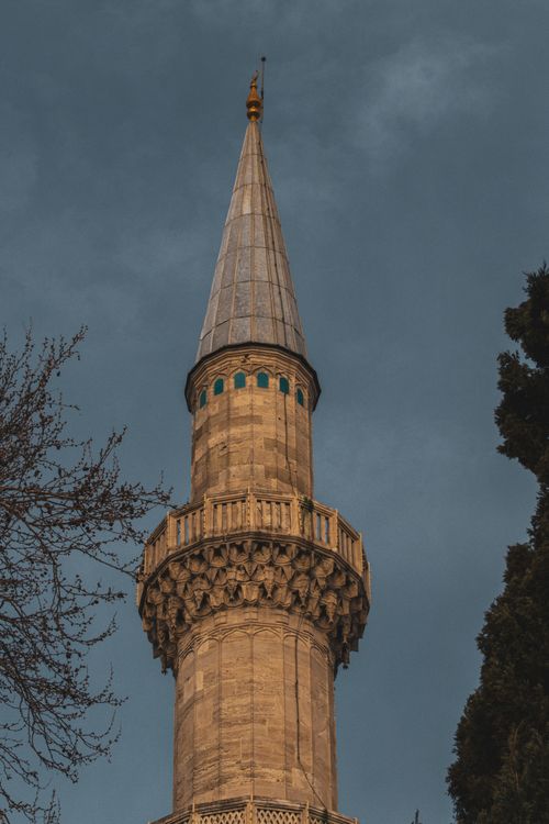 Free Close-up view of a historic stone minaret set against a cloudy sky, offering compelling architectural detail. Stock Photo