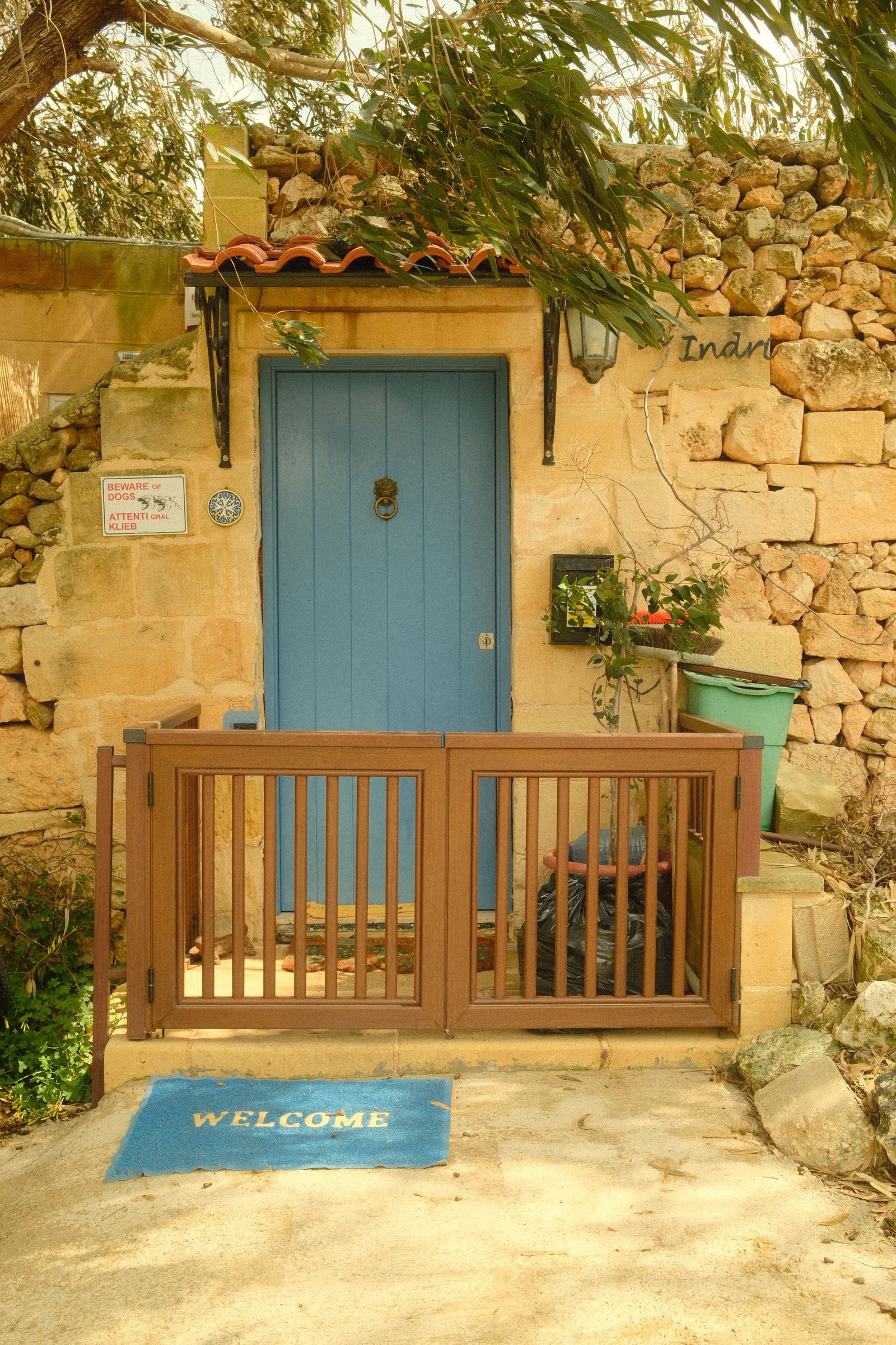 Blue front door with a small knocker against a warm stone entrance.