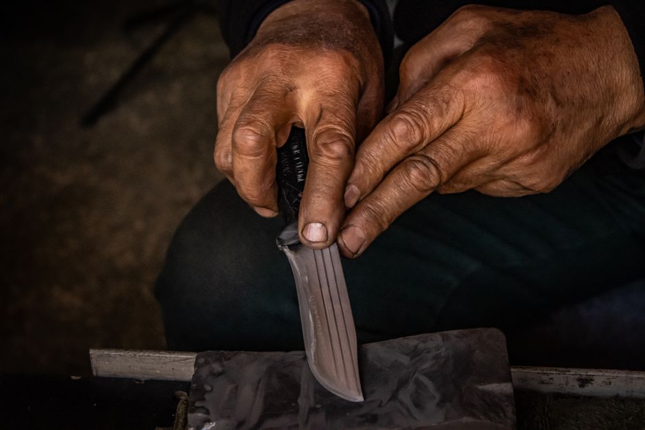 Close-up of a blade being sharpened on a whetstone — the same technique used to sharpen pruning shears in Surrey BC