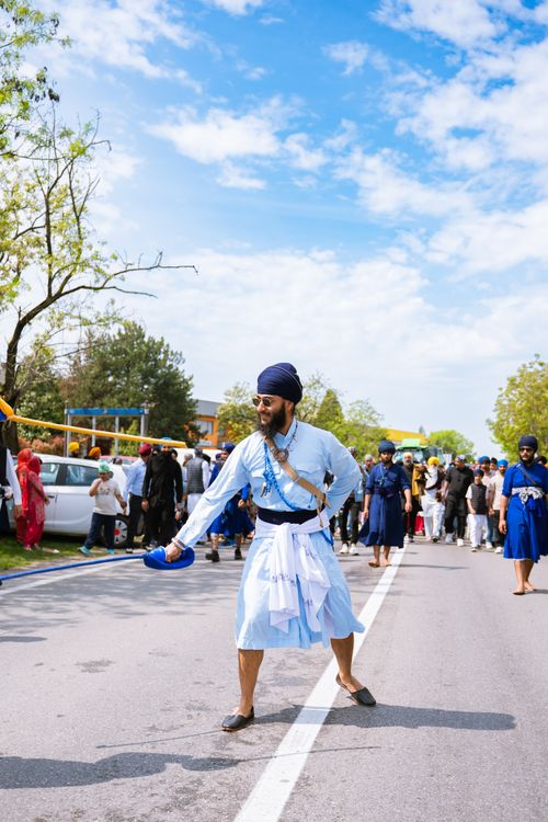 Free A vibrant Sikh parade showcasing traditional dress and cultural practices outdoors. Stock Photo
