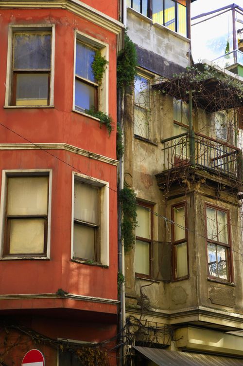 Free Old urban buildings with ivy-covered facades and vintage balconies. Stock Photo