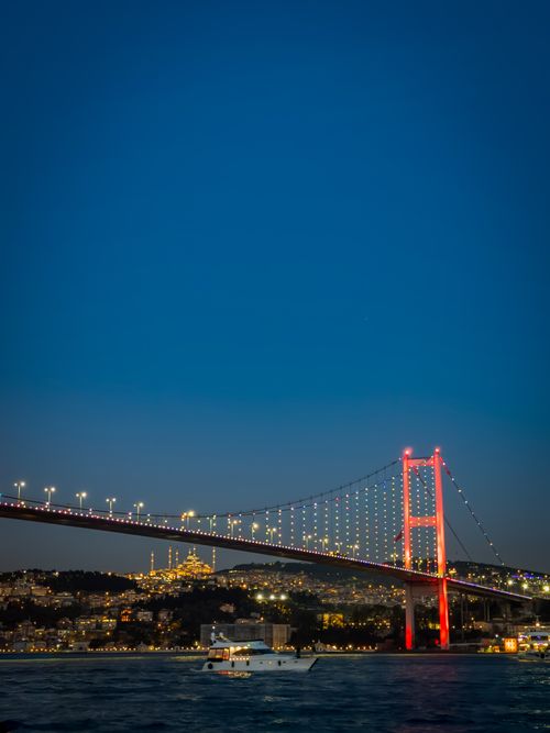 Free A vibrant night scene of the Bosphorus Bridge lit with colorful lights over the Istanbul skyline. Stock Photo