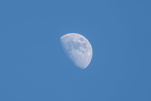 Free A high-resolution image of the moon during its waxing gibbous phase against a clear blue sky. Stock Photo