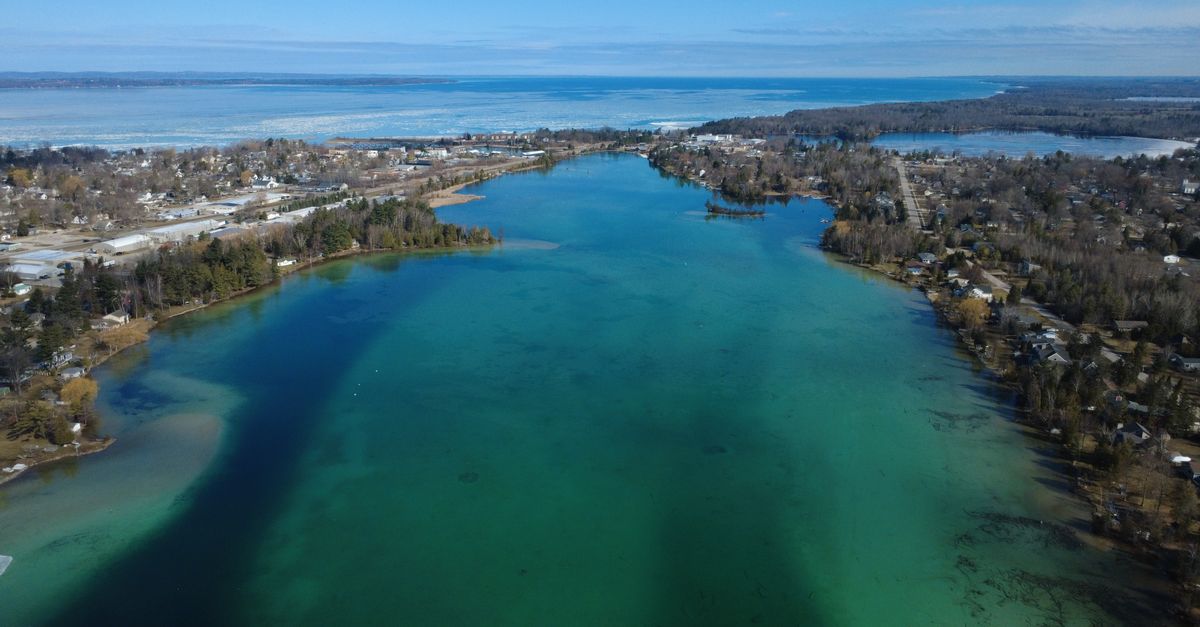 Stunning aerial shot of Torch Lake showcasing vibrant blue-green water and surrounding landscape.
