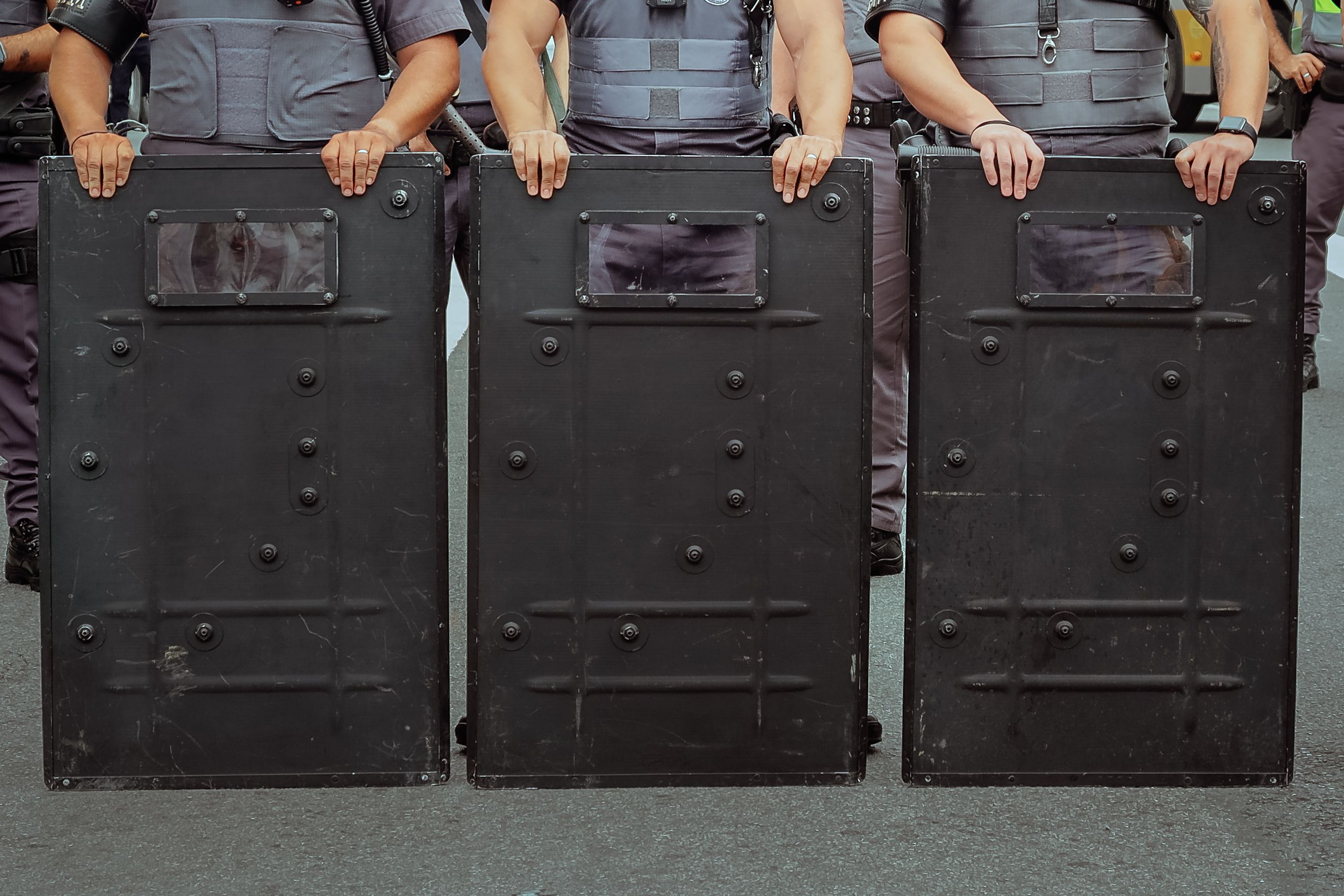 Riot Police Standing Firm Behind Shields · Free Stock Photo
