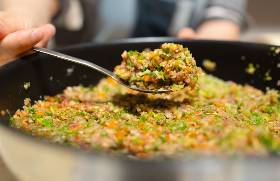 Golden sautéed mirepoix vegetables cooking in a black skillet`