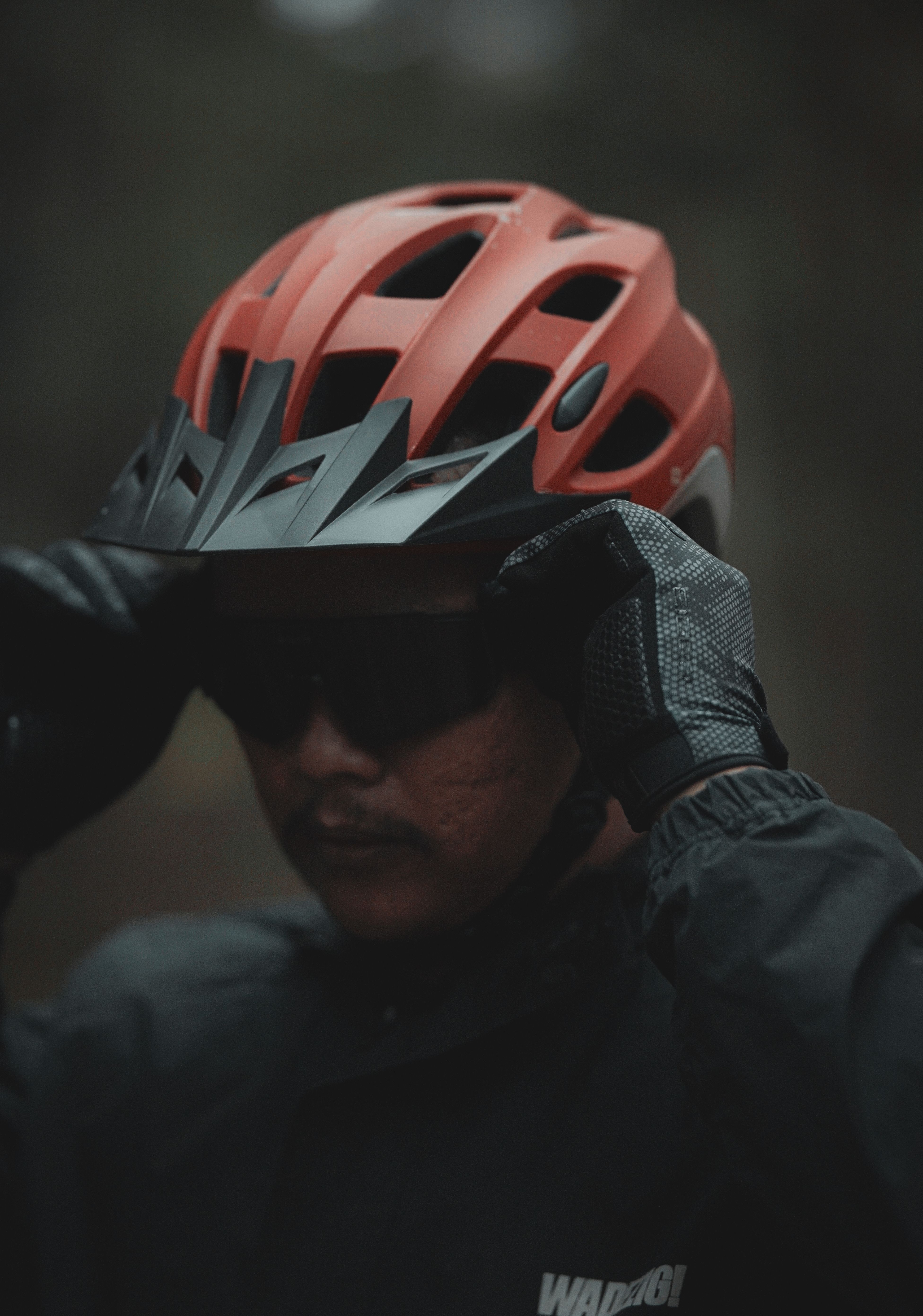 Cyclist adjusting a helmet and preparing cycling gear before a ride