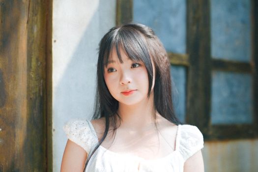A serene portrait of a young woman bathed in gentle sunlight.